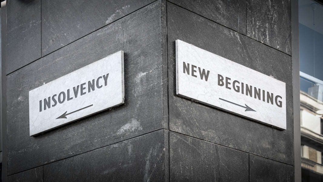 Street sign with directions to either NEW BEGINNING or INSOLVENCY