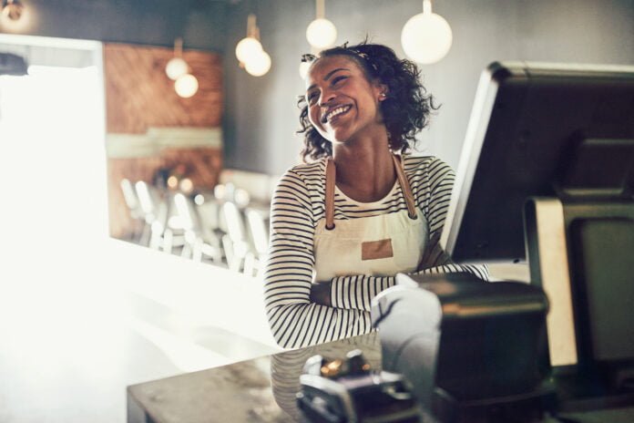 Young waitress standing at an order terminal