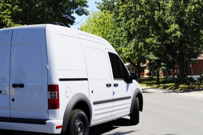 White delivery van making a left turn on the street